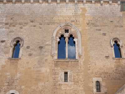 ...si aprono delle eleganti bifore che illuminano i saloni del piano nobile sovrastante. Sono originali, realizzate in epoca sveva